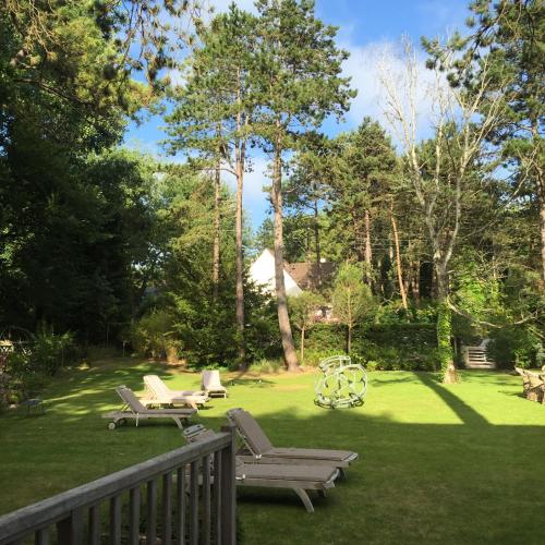 a yard with chairs and a playground in the grass at Demeure d'Hôtes Haec Otia in Le Touquet-Paris-Plage