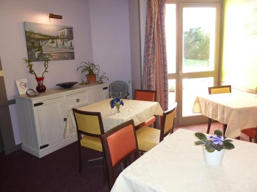 a kitchen with a table, chairs and a refrigerator at Les Jardins du Forez in Montrond-les-Bains