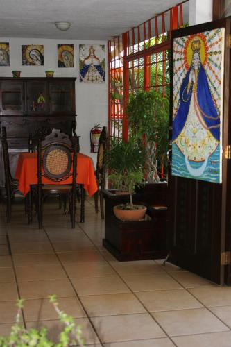 a dining room with a table and chairs and stained glass windows at La Posada del Arcangel in Managua