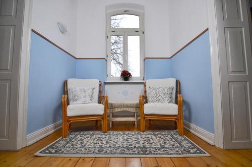 a room with two chairs and a window at Altes Pfarrhaus Gondershausen in Gondershausen