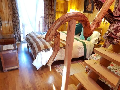 a bedroom with a bed with a wooden frame at Cabañas Rukas Licantén in Licantén