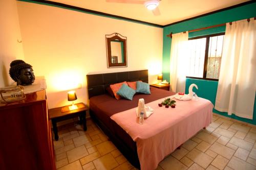 Un dormitorio con una cama con flores. en Maya Vacanze Playa Alegria, en Playa del Carmen