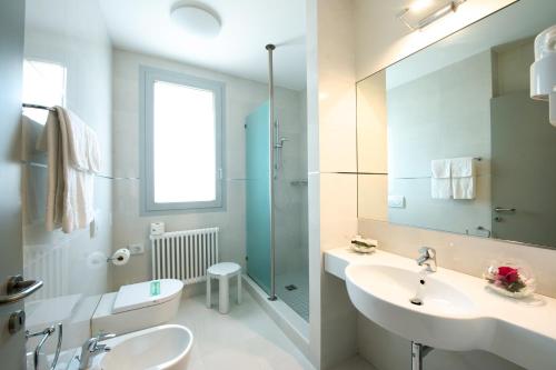 a white bathroom with a sink and a mirror at Hotel Ristorante Primavera in Godega di SantʼUrbano