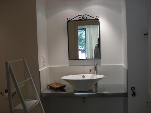 W łazience znajduje się biała umywalka i lustro. w obiekcie Lou Ventoulet w mieście Mouriès