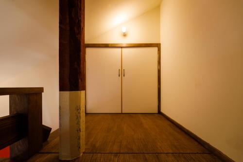 a hallway with a white door and a wooden floor at Teramachiya Wind Bell Temple Guest House in Kanazawa