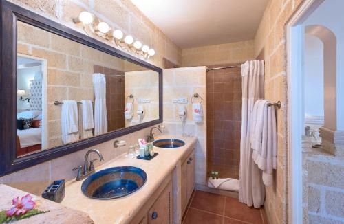 a bathroom with two sinks and a large mirror at Little Arches Boutique Hotel - Adults Only in Christ Church