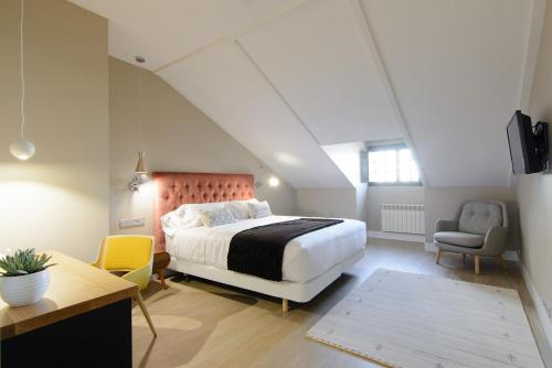 a bedroom with a bed and a desk and a chair at Pazo de Mendoza in Baiona