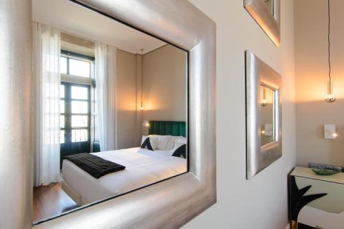 a mirror on a wall with a bed in a room at Pazo de Mendoza in Baiona