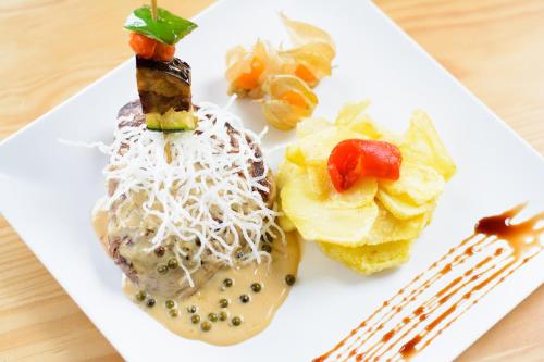 a plate of food with a doughnut and fruit at Pazo de Mendoza in Baiona