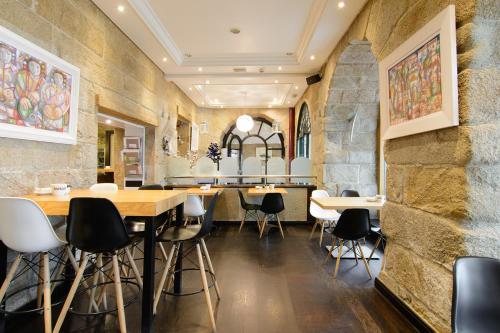 a restaurant with stone walls and tables and chairs at Pazo de Mendoza in Baiona