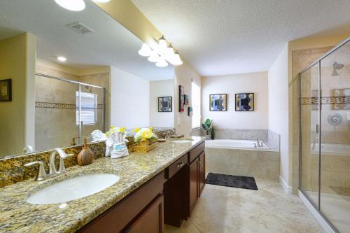 a bathroom with two sinks and a shower and a tub at DISNEY area Luxurious House-Private Pool in Kissimmee