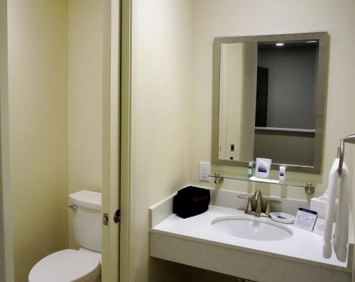 a bathroom with a sink and a toilet and a mirror at Best Western Seattle Airport Hotel in SeaTac