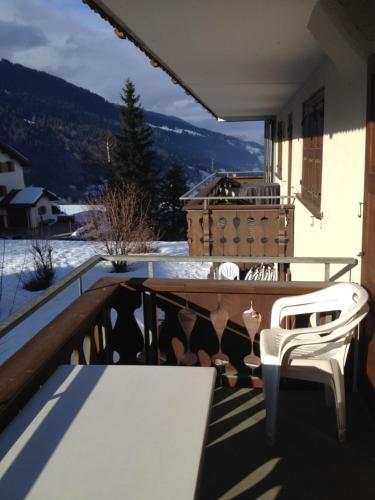 a balcony with a table and two white chairs at Haus Fless 7 in Klosters Dorf