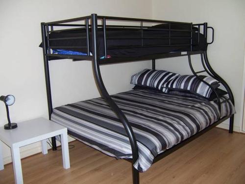 a black bunk bed with a striped pillow on it at Relax On Par in Port Hughes