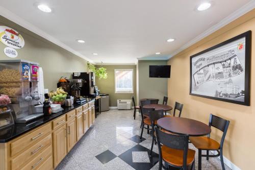 a restaurant with a table and chairs and a counter at Super 8 by Wyndham Indianapolis-Southport Rd in Indianapolis