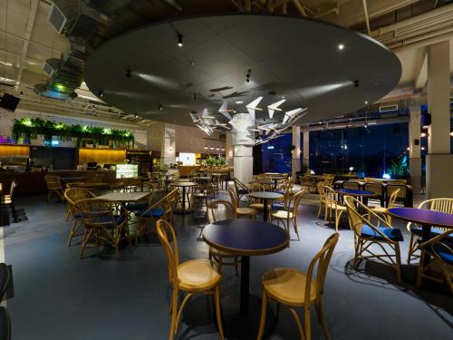 a restaurant with tables and chairs and a large chandelier at Tune Hotel KLIA-KLIA2, Airport Transit Hotel in Sepang