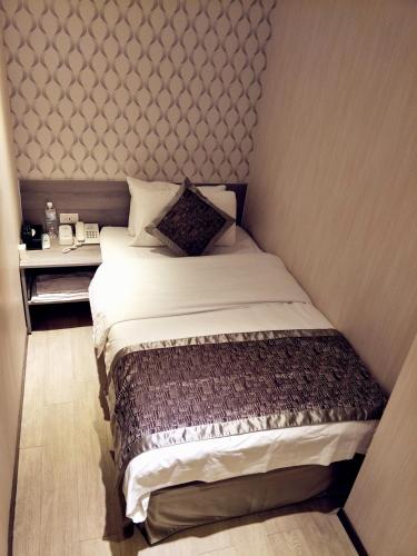 a small bedroom with a bed in the corner at I Play Inn TP in Taipei