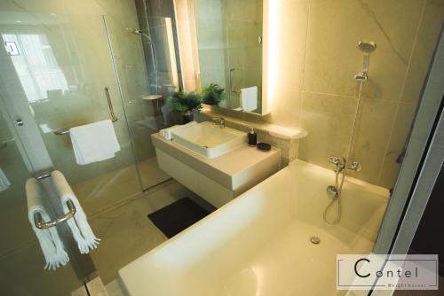 a bathroom with a tub and a sink and a shower at The Astra Condo Chiang Mai - A624 in Chiang Mai