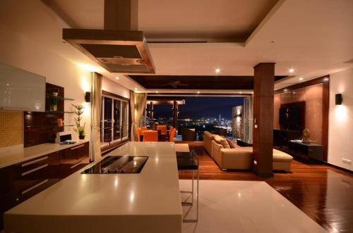 a kitchen and living room with a view of the city at AW ONE Patong Villa in Patong Beach