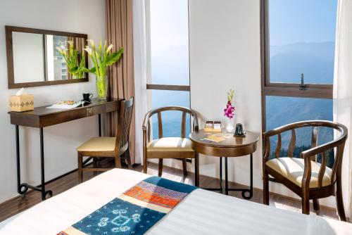 a hotel room with a bed and a table and chairs at Amazing Hotel Sapa in Sapa