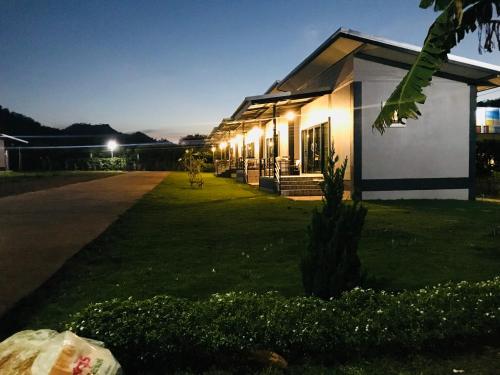 a house with lights on the side of it at night at Lek Village Khaoyai in Pak Chong