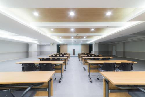 an empty lecture room with tables and chairs at Reborn Suwon Silkroad Hotel in Suwon