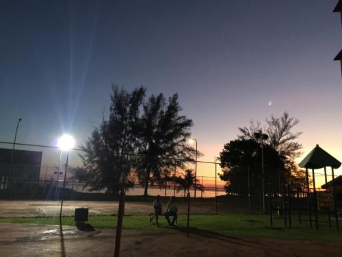 two people are playing in a park at night at Sunshine Bay Resort Port Dickson in Port Dickson
