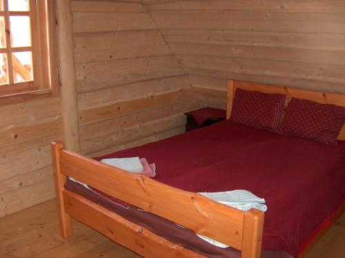 a bedroom with a bed in a log cabin at Zirgu sēta "Klajumi" - Horse ranch "Klajumi" in Kaplava