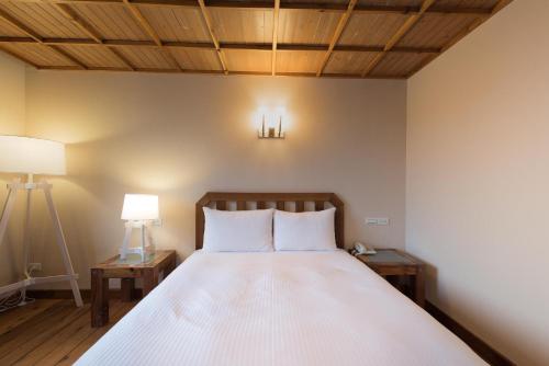 a bedroom with a bed with two night stands and two lamps at Chilan Hotel in Datong