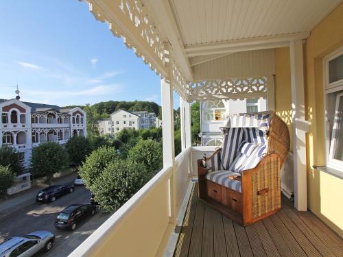 a chair on a balcony with a view of a street at Villa Freya - Apt. 04 in Ostseebad Sellin