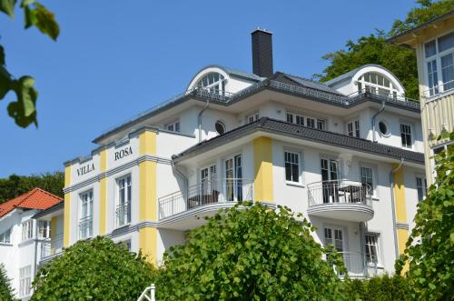 un grand bâtiment blanc et jaune avec balcon dans l'établissement Villa Rosa - Apt. 05, à Sellin