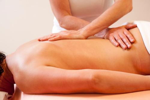 a woman getting a massage from a therapist at Hotel Gutshaus Parin - Bio- und Gesundheitshotel in Parin