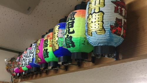 a row of colorful paper lanterns on a shelf at Kagoshima Little Asia in Kagoshima