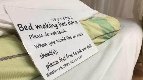 a sign sitting on top of a bed making mistakes at Kagoshima Little Asia in Kagoshima