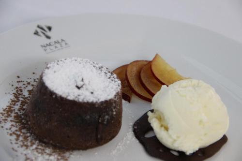 a plate with a piece of cake and ice cream at Nacala Plaza Business Design Hotel in Cidade de Nacala