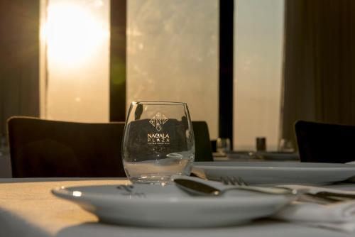 a wine glass sitting on a table with a plate at Nacala Plaza Business Design Hotel in Cidade de Nacala
