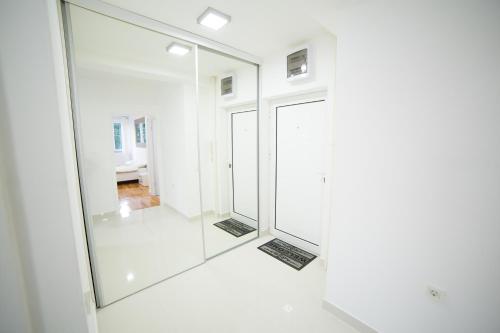 ein Bad mit einem großen Spiegel im Zimmer in der Unterkunft Bor Apartment in Bor