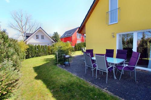 a table and chairs in a yard next to a house at Ferien_HAUS SEEBRISE in Göhren-Lebbin