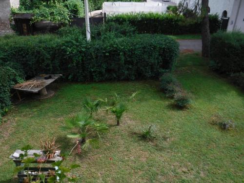 a garden with a bench and plants in the grass at Stasion Di Pueste in Nogaredo Al Torre