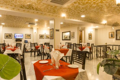 a restaurant with tables and chairs in a room at Umaid Residency - A Regal Heritage Home in Jaipur