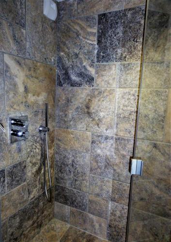 une douche avec une porte vitrée dans une salle de bain dans l'établissement Domaine des Maréquiers chambre Pimprenelle, à Saint-Germain-du-Teil