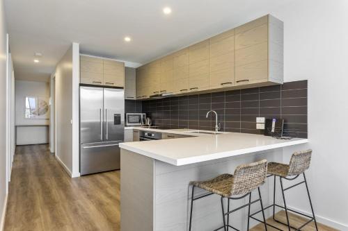 a kitchen with a counter and two bar stools at Blairgowrie Apartment 1 - on the beach in Blairgowrie