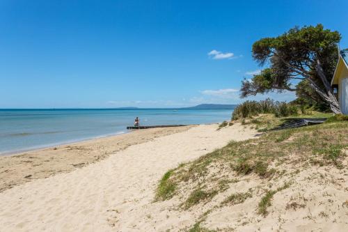 a person sitting on a pier on a beach at Blairgowrie Apartment 1 - on the beach in Blairgowrie