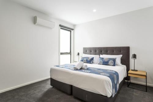 a bedroom with a large bed and a window at Blairgowrie Apartment 2 - on the beach in Blairgowrie