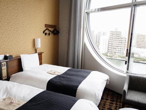 ein Hotelzimmer mit 2 Betten und einem Fenster in der Unterkunft APA Hotel Nihombashi Hamacho-eki Minami in Tokio
