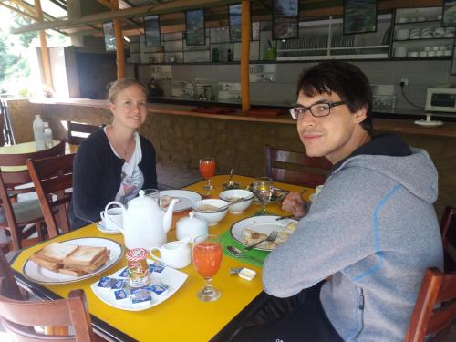 a man and a woman sitting at a table with food at Train View Chalet in Bandarawela