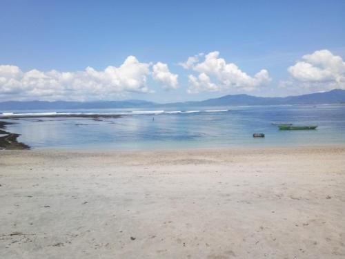 a beach with a boat in the water at Rock Pool Homestay in Huu