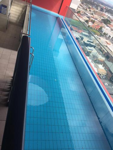 a blue and white swimming pool with blue walls at RNR Serviced Apartments Adelaide - Grote St. in Adelaide