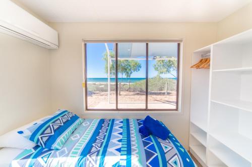 a bedroom with a bed and a view of the ocean at Mackerel Islands in Onslow