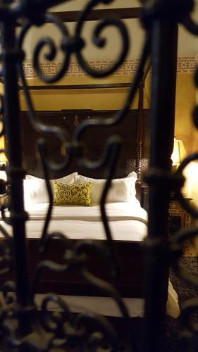 a black bed with white sheets and pillows at Palais didi in Meknès